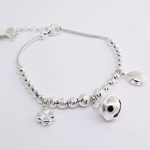 Pulsera tubito bolitas facetadas, con dijes colgantes, trebol, llamador de angel, y vaquita de san antonio